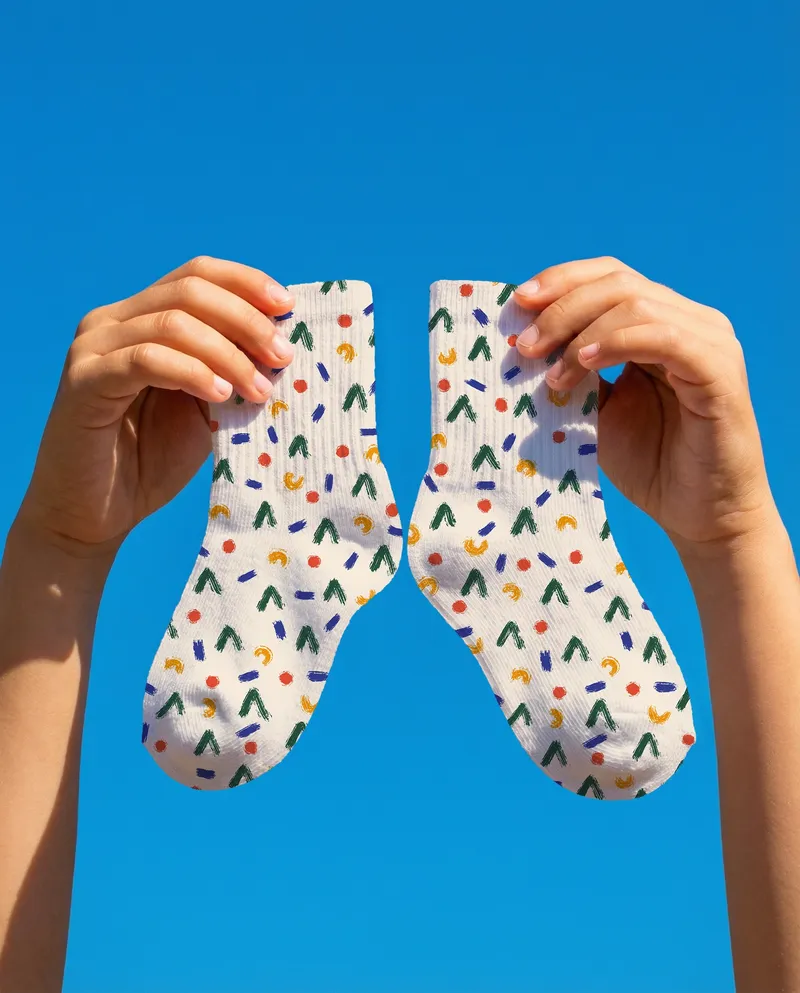 Handheld Socks Mockup Against Blue Sky